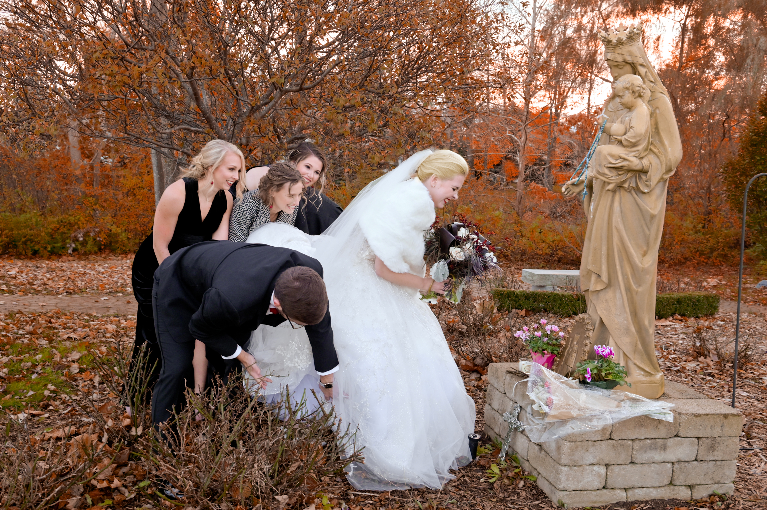 Bride is tangled in rose bushes while praying to St. Therese.