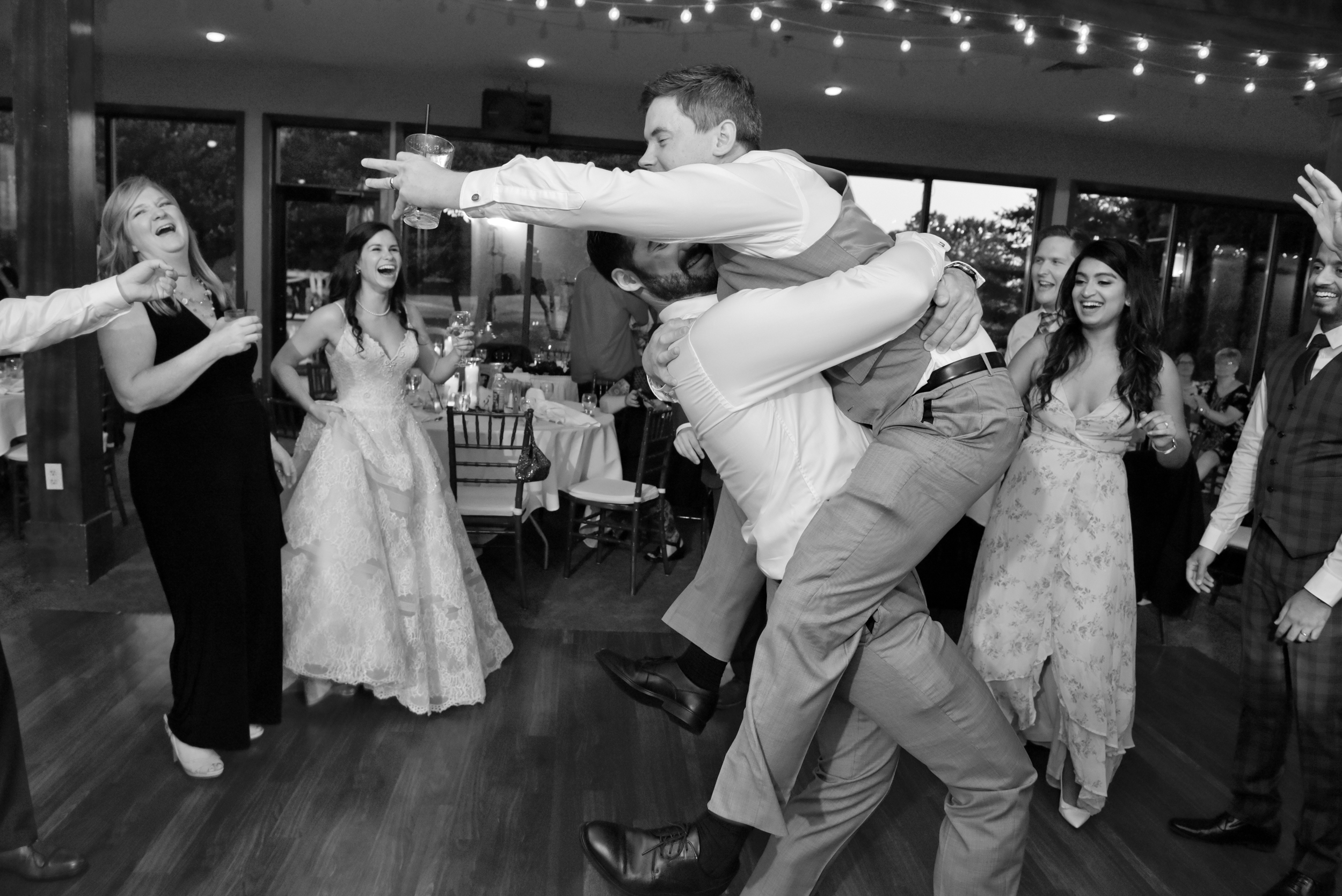 Groom jumps into guest's arms during his wedding reception at Stonebridge Golf in Ann Arbor, Michigan.