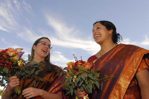 Michigan wedding photography captures candid moments as the bride and maid of honor wait for the beginning of the Hindu wedding ceremony in Freeland Michigan to start