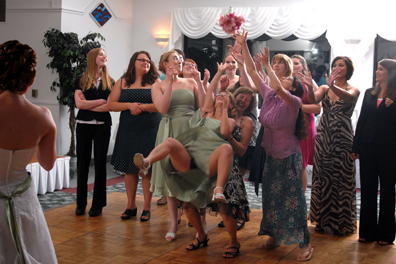 The bridesmaid gives it her all (and a peek a boo show) trying to catch the bouquet